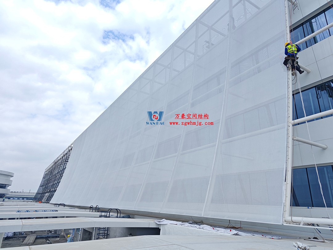聚焦工程高質量建設，這個網格織物幕墻正在施工安裝中